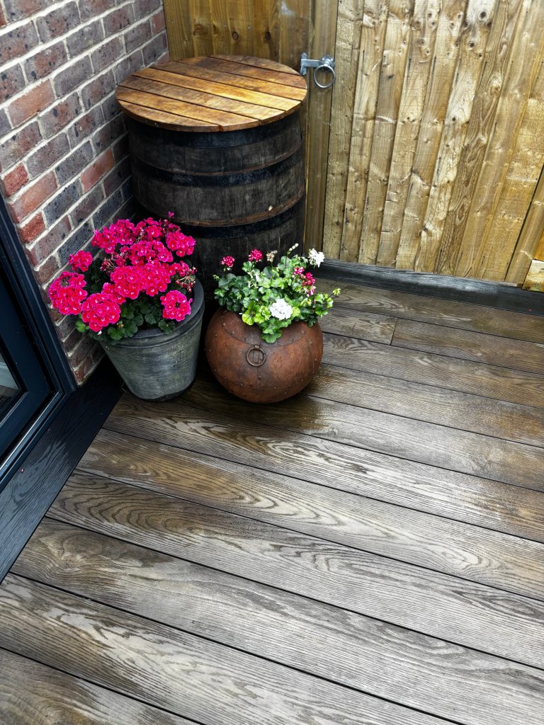 Outdoor dining space on Millboard decking terrace in contemporary garden