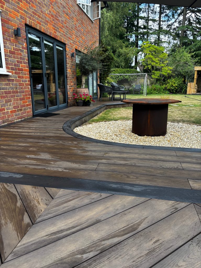 Curved Millboard deck and transition walkway in modern landscaped garden